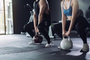 A person performing a dumbbell deadlift with proper posture.