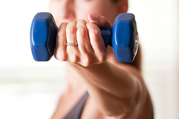 A person performing lateral raises with dumbbells in a standing position.