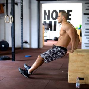 A lifter lying on a bench performing dumbbell skull crushers.